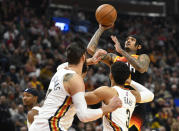 Utah Jazz guard Jordan Clarkson, right, shoots over New Orleans Pelicans players Jonas Valanciunas, left, and Josh Hart, center, during the first half of an NBA basketball game Friday, Nov. 26, 2021, in Salt Lake City. (AP Photo/Alex Goodlett)