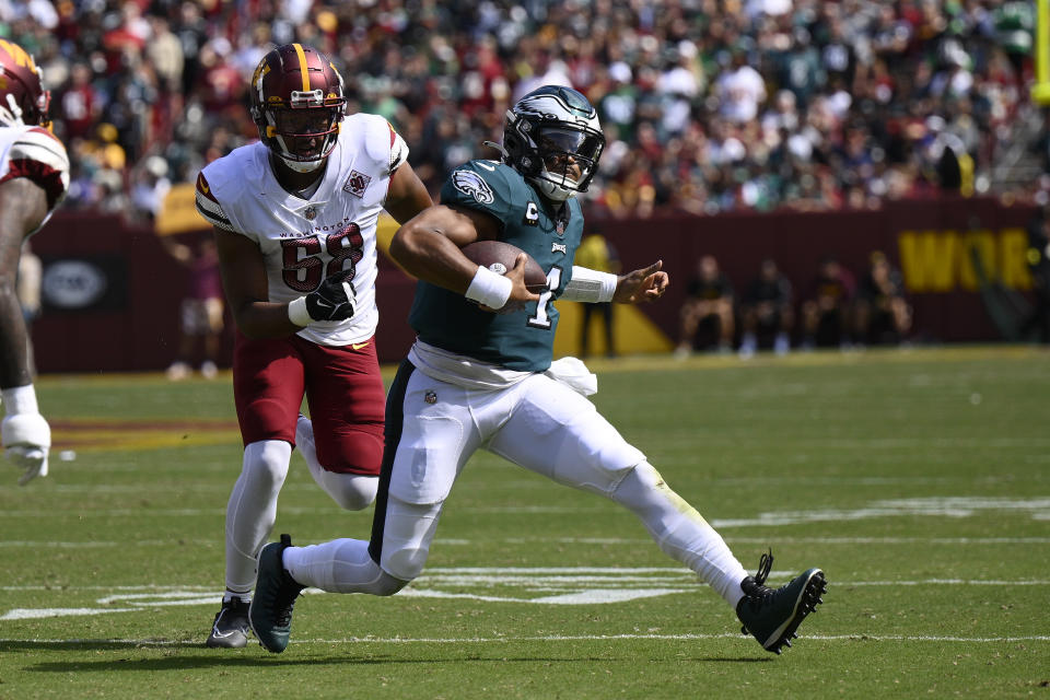 Philadelphia Eagles quarterback Jalen Hurts (1) scrambles past Washington Commanders defensive end Shaka Toney (58) during the first half of an NFL football game, Sunday, Sept. 25, 2022, in Landover, Md. (AP Photo/Nick Wass)