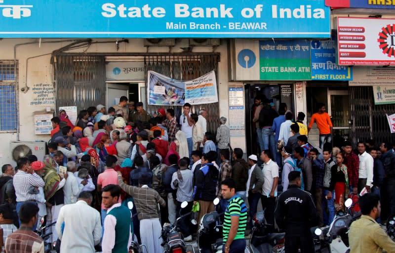 FILE PHOTO: People crowd the entrance of the State Bank of India branch to deposit or exchange their old high denomination banknotes in Beawar city