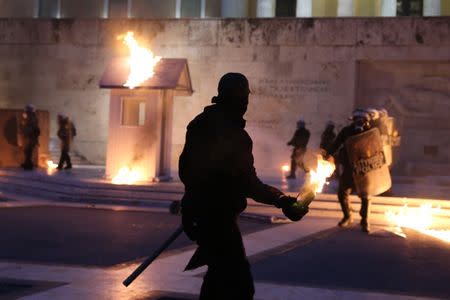 A masked demonstrator prepares to throw a petrol bomb to riot police outside the parliament building as Greek lawmakers vote on the latest round of austerity Greece has agreed with its lenders, in Athens, Greece, May 18, 2017. REUTERS/Costas Baltas