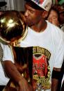 Michael Jordan kisses the championship trophy after the Bulls finished off the Seattle Supersonics in six games in the 1996 NBA Finals. (Getty Images)