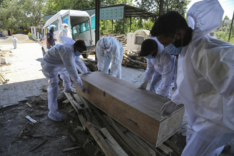 Health workers and relatives carry the body of a COVID-19 victim for cremation in Jammu, India, Monday, May 24, 2021. India crossed another grim milestone Monday of more than 300,000 people lost to the coronavirus as a devastating surge of infections appeared to be easing in big cities but was swamping the poorer countryside. (AP Photo/Channi Anand)