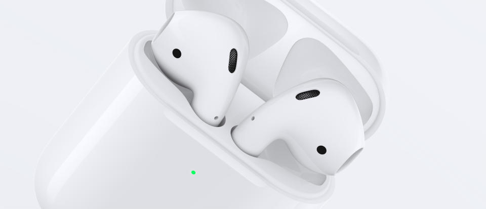 A pair of Apple AirPods in a charging dock.