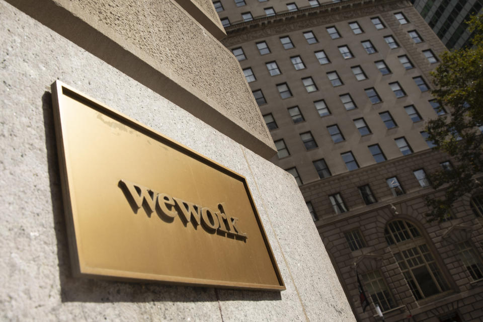 FILE - This Sept. 30, 2019 file photo shows a WeWork sign on a building in New York. Japanese technology giant SoftBank has committed billions of dollars to bailing out office space sharing startup WeWork. (AP Photo/Mark Lennihan, File)