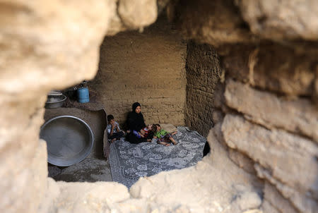 Wife and sons of Youssef Abdullah, one of at least 22 Egyptians found dead earlier this month, perishing from heat and starvation after trekking the Libyan desert by foot, sit on a carpet in the village of Tarfa al-Kom in Minya province, Egypt, July 12, 2017. Picture taken July 12, 2017. REUTERS/Mohamed Abd El Ghany