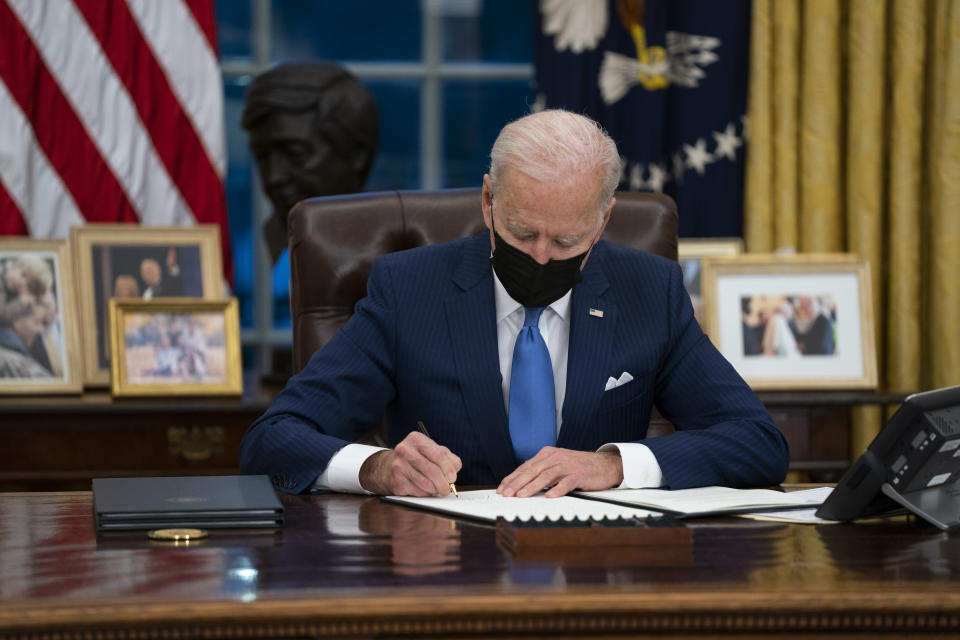 FILE - In this Feb. 2, 2021, file photo, President Joe Biden signs an executive order, in the Oval Office of the White House, in Washington. Biden is signing an executive order Wednesday to review the United States’ supply chains for large capacity batteries, pharmaceuticals, critical minerals and semiconductors. (AP Photo/Evan Vucci, File)