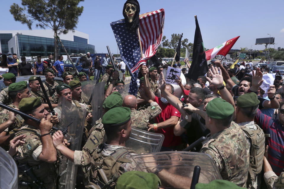 Hezbollah supporters scuffle with Lebanese army soldiers while protesting the visit by Gen. Frank McKenzie, the head of U.S. Central Command, outside ​​the Rafik Hariri International Airport in Beirut, Lebanon, Wednesday, July 8, 2020. (AP Photo/Bilal Hussein)