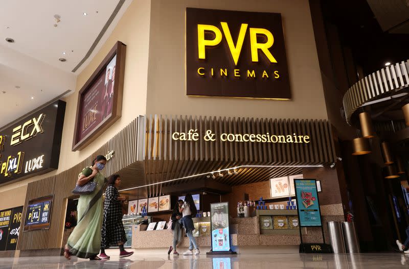 FILE PHOTO: Women walk outside a PVR movie theatre in Mumbai