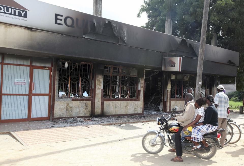 Residents of Mpeketoni view the damage left behind at the Equity bank after unidentified gunmen attacked the coastal Kenyan town of Mpeketoni, June 16, 2014. (REUTERS/Joseph Okanga)