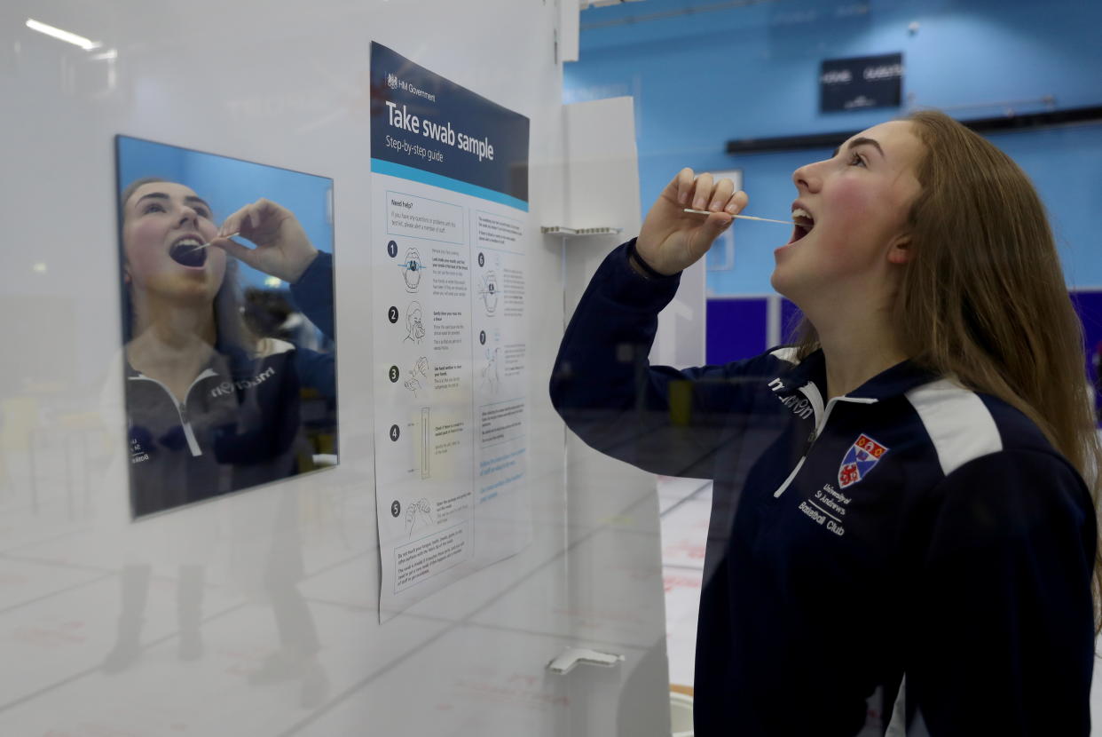 A young woman takes a lateral flow antigen test at a facility in St Andrews, Scotland, Britain. Photo: Russell Cheyne/Reuters