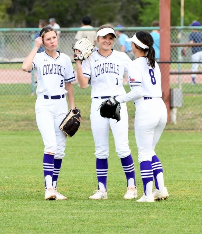 Mason softball's Kamryn Loeffler (middle) talks with teammates in the outfield during a game.