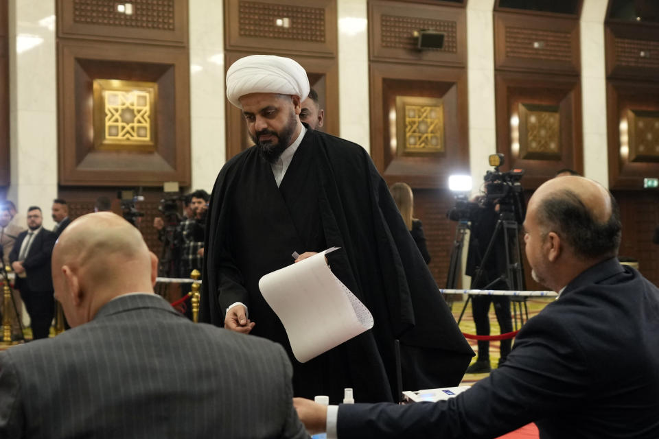 Qais al-Khazali, center, the leader of the militant Shiite group Asaib Ahl al-Haq, casts his vote in the country's provincial elections in Baghdad, Iraq, Monday, Dec.18, 2023. (AP Photo/Hadi Mizban)