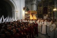 Penitents wait inside a church before they take part in the "Humildad" brotherhood Palm Sunday procession at the start of Holy Week in Malaga, southern Spain, April 13, 2014. Hundreds of Easter processions take place round-the-clock during Holy Week in Spain, drawing thousands of visitors. REUTERS/Jon Nazca (SPAIN - Tags: SOCIETY RELIGION)