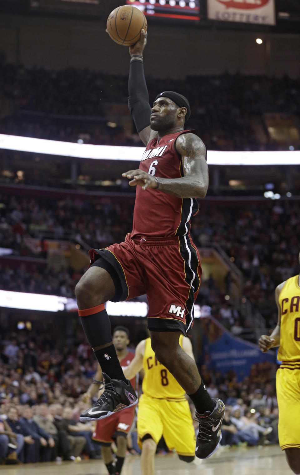 Miami Heat's LeBron James (6) jumps to the basket against the Cleveland Cavaliers during the first quarter of an NBA basketball game Tuesday, March 18, 2014, in Cleveland. (AP Photo/Tony Dejak)