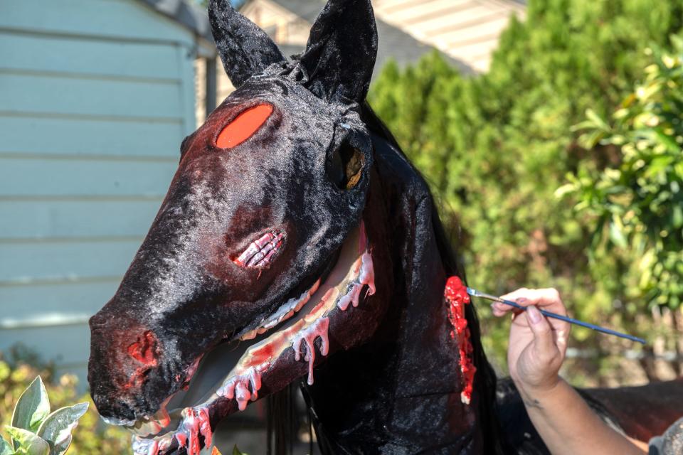 Jeanna Pack works on the Headless Horseman's steed Halloween decoration in her front yard on Oro Avenue near Farm Street in east Stockton on Thursday, Sept. 22, 2022. Pack has been doing elaborate Halloween displays at her home for the past 26 years.