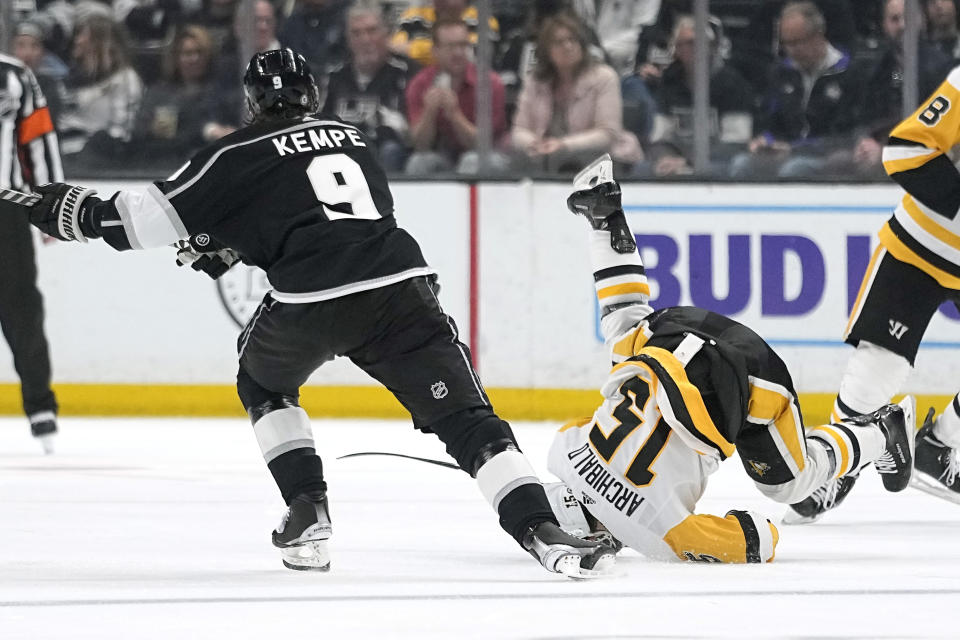 Pittsburgh Penguins right wing Josh Archibald, right, tumbles as Los Angeles Kings right wing Adrian Kempe skates by during the second period of an NHL hockey game Saturday, Feb. 11, 2023, in Los Angeles. (AP Photo/Mark J. Terrill)