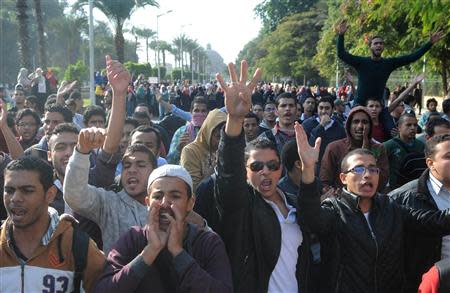 Students of Cairo University, who are supporters of the Muslim Brotherhood and ousted Egyptian President Mohamed Mursi, shout slogans against the military and interior ministry during a demonstration in front of at the main gate of the university in Cairo December 9, 2013. REUTERS/Stringer