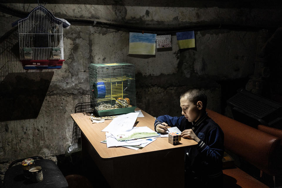 Tymophey, 8, paints in the basement of the kindergarten in Kutuzivka, Ukraine, on May 20, 2022. The village of Kutuzivka was occupied by Russia for weeks and liberated by the Ukrainian army on April 27, 2022. The village was heavily destroyed during fighting, and people are still living in basements in fear of future shelling.<span class="copyright">Serhii Korovainyi</span>