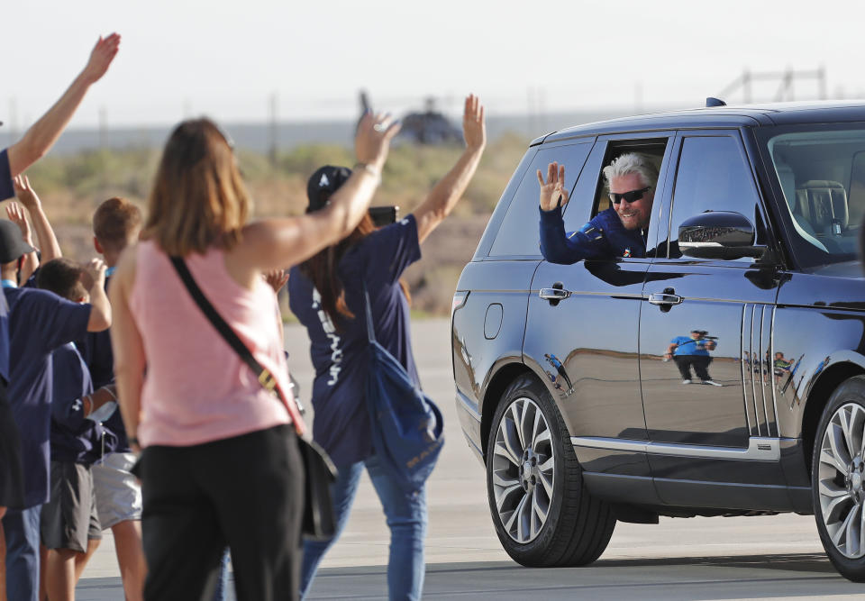 Virgin Galactic founder Richard Branson waves to school children while heading to board the rocket plane that will fly him to space from Spaceport America near Truth or Consequences, New Mexico, Sunday, July 11, 2021. (AP Photo/Andres Leighton)