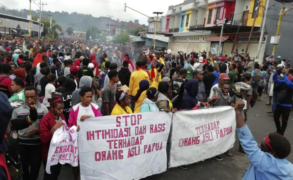 People display banners that read "Stop intimidation and racism towards indigenous Papuans" during a protest in Manokwari, Papua province, Indonesia, Monday, Aug. 19, 2019. The protest was sparked by accusations that Indonesian police who backed by the military, have arrested and insulted dozens of Papuan students in their dormitory in East Java's cities of Surabaya and Malang a day earlier. (AP Photo/Safwan Ashari Raharusun)