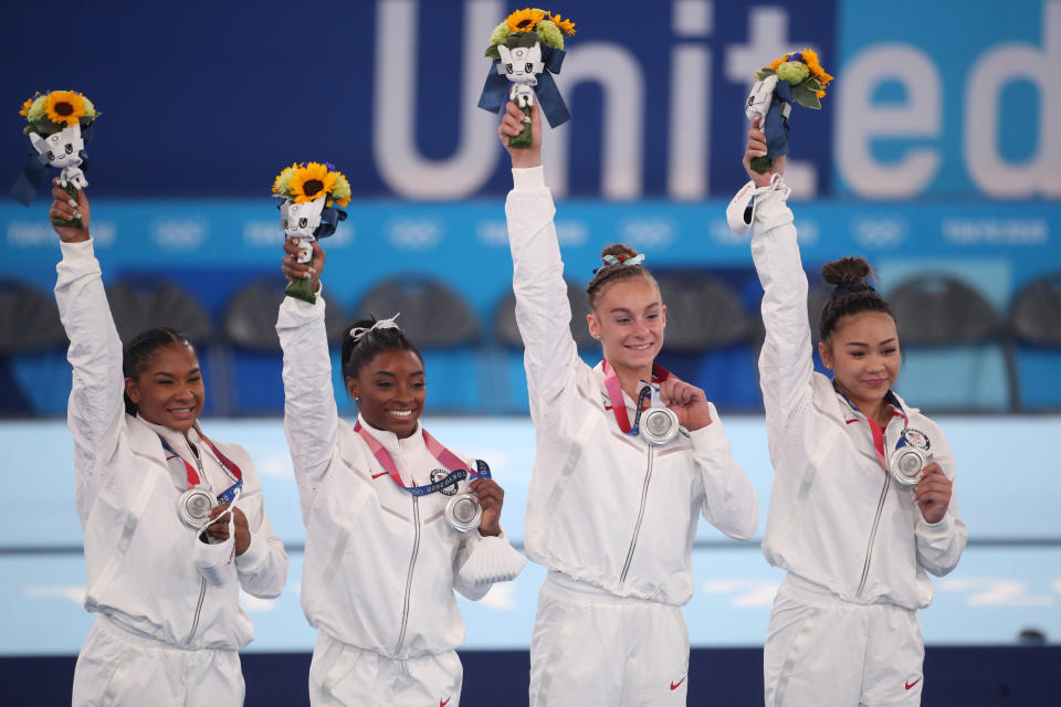 The U.S. Women's Gymnastics team saluting the crowd and posing with their medals