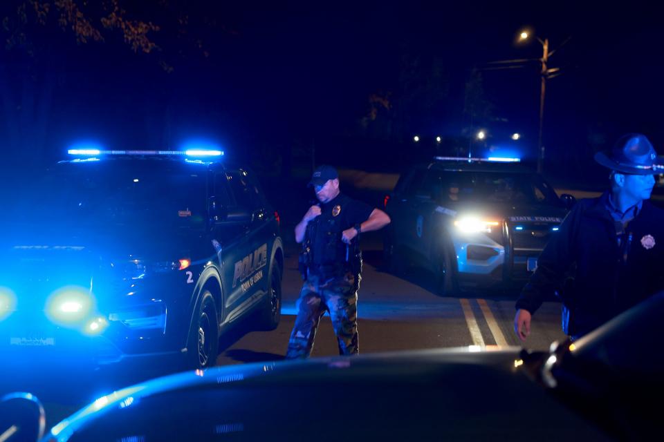 Officers stand near the area where Robert Card was found dead on October 27, 2023, after mass shootings in Lewiston, Maine. Police say Mr. Card killed 18 people in a mass shooting at a bowling alley and restaurant in Lewiston, was found dead in nearby Lisbon.