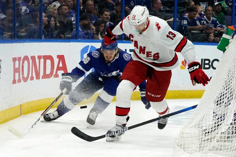 Carolina Hurricanes left wing Warren Foegele (13) loses his stick as he moves the puck in front of Tampa Bay Lightning defenseman Mikhail Sergachev (98) during the first period in Game 4 of an NHL hockey Stanley Cup second-round playoff series Saturday, June 5, 2021, in Tampa.