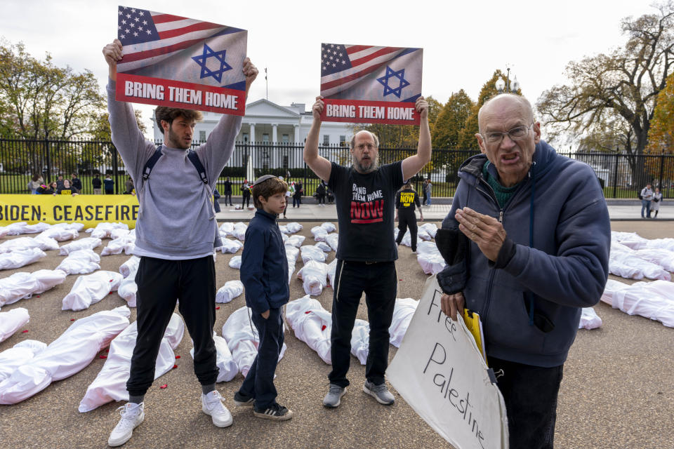 FILE - A family visiting from New Jersey holding up posters in support of bringing Israeli hostages home, clashes with a pro-Palestine supporter, right, in front of a large banner that says "Biden: Ceasefire Now" along with fake white body bags, representing those killed in the escalating conflict in Gaza and Israel, is displayed in front of the White House, Wednesday, Nov. 15, 2023, in Washington. State lawmakers across the country are expected consider legislation related to the Israel-Hamas war in 2024. (AP Photo/Andrew Harnik, File)