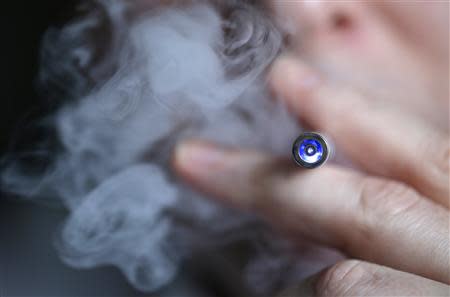 A man smokes an electronic cigarette, a substitute slightly longer than a normal cigarette, in this illustration file picture taken in Paris March 5, 2013. REUTERS/Christian Hartmann/Files