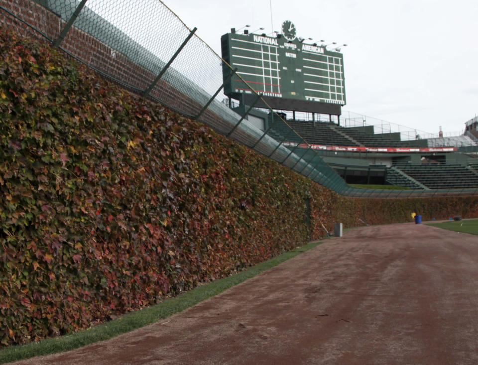 FILE - This Oct. 25, 2011, file photo, shows the outfield ivy and iconic manual scoreboard at Wrigley Field in Chicago. Getting a side to give back something it gained previously in collective bargaining can lead to difficult negotiations, which is why Major League Baseball has its first work stoppage in 26 years. (AP Photo/Charles Rex Arbogast, File)