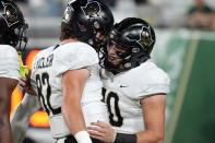 UCF quarterback John Rhys Plumlee (10) celebrates with tight end Alec Holler (82) after scoring on a 64-yard touchdown run against South Florida during the first half of an NCAA college football game Saturday, Nov. 26, 2022, in Tampa, Fla. (AP Photo/Chris O'Meara)