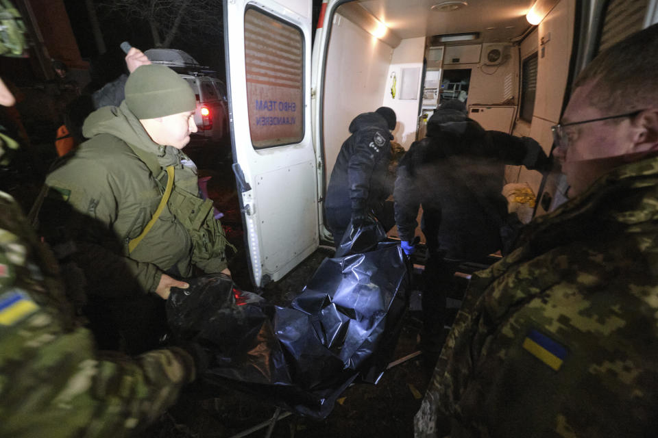 Police officers carry a body which was killed by a Russian rocket attack at residential neighbourhood in Kramatorsk, Ukraine, on Thursday, Feb. 2, 2023. At least 3 people were killed and 21 wounded in the attack. (AP Photo/Yevgen Honcharenko)