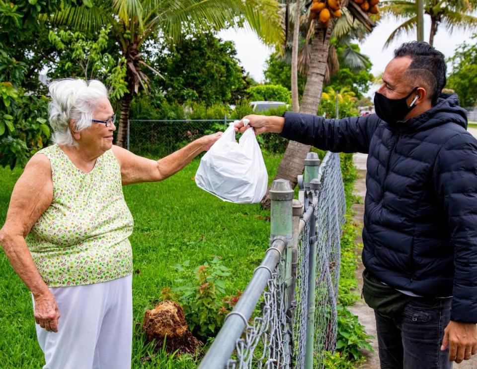 Rodríguez gives a meal to a woman in Homestead while out on delivery for Lean Culinary Services LLC.