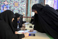 An Iranian woman registers to cast her vote during the parliament elections at a polling station in Tehran, Iran, Friday, Feb. 21, 2020. Iranians began voting for a new parliament Friday, with turnout seen as a key measure of support for Iran's leadership as sanctions weigh on the economy and isolate the country diplomatically. (AP Photo/Ebrahim Noroozi)