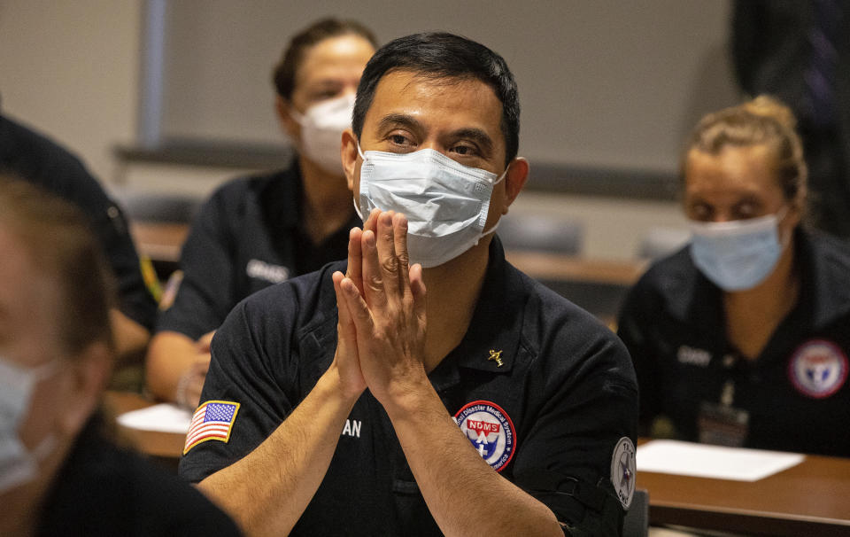 After his hands were blessed by a priest, Matthew Tran, a pharmacist prays with nearly three dozen other healthcare workers from around the country who arrived to help supplement the staff at Our Lady of the Lake Regional Medical Center in Baton Rouge, La., Monday, Aug. 2, 2021. Louisiana has one of the lowest coronavirus vaccination rates in the nation and is seeing one of the country’s worst COVID-19 spikes. (AP Photo/Ted Jackson)