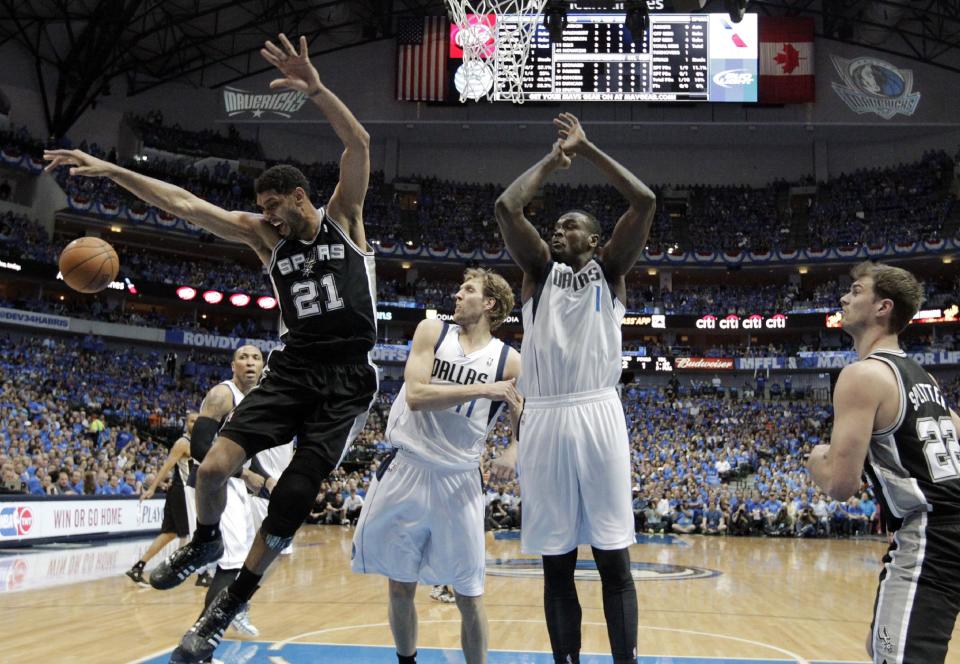 San Antonio Spurs' Tim Duncan (21) loses control of the ball after being fouled by Dallas Mavericks' Dirk Nowitzki (41) beneath the basket as Samuel Dalembert (1) and Tiago Splitter (22) watch in the first half of Game 4 of an NBA basketball first-round playoff series, Monday, April 28, 2014, in Dallas. (AP Photo/Tony Gutierrez)