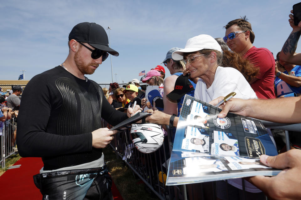 Tyler Reddick signs autographs before a NASCAR Cup Series auto race at Kansas Speedway in Kansas City, Kan., Sunday, Sept. 10, 2023. (AP Photo/Colin E. Braley)