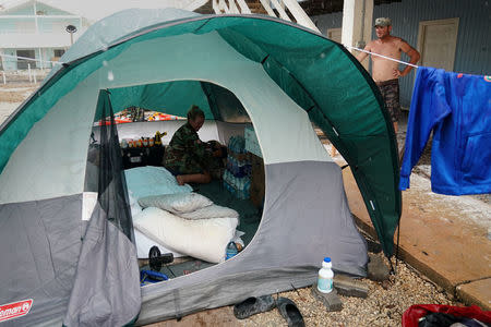 A man looks at his tent as it rains before having a disagreement with his friend following Hurricane Irma in Cudjoe Key, Florida, U.S., September 14, 2017. REUTERS/Carlo Allegri