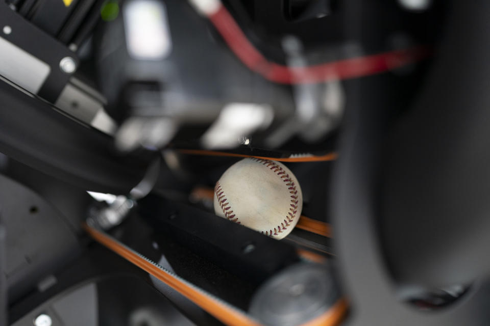 A baseball travels through the Trajekt Arc pitching machine as it is demonstrated at the Major League Baseball winter meetings Wednesday, Dec. 6, 2023, in Nashville, Tenn. (AP Photo/George Walker IV)