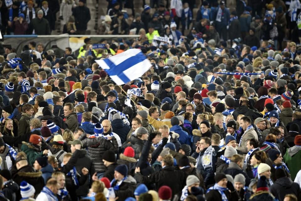 Finnish fans join players to celebrate their victory in the Euro 2020 Group J qualifying soccer match between Finland and Liechtenstein in Helsinki, Finland, on Friday, Nov. 15, 2019. Finland won 3-0 and have qualified for a major soccer tournament for the first time in their history. (Martti Kainuleinen/Lehtikuva via AP)