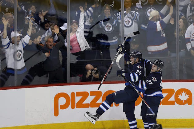 Winnipeg Jets' Nikolaj Ehlers (27) and Patrik Laine (29) celebrate Laine's overtime goal against the Toronto Maple Leafs in an NHL hockey game Wednesday, Oct. 19, 2016, in Winnipeg, Manitoba. (John Woods/The Canadian Press via AP)