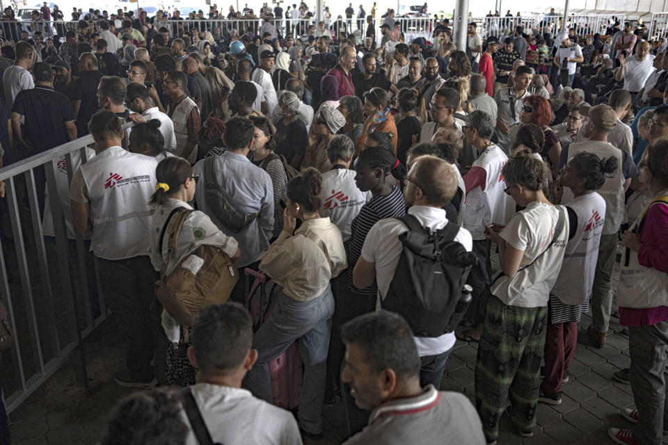 Palestinians and foreign aid workers wait to cross into Egypt at Rafah, Gaza Strip, (Fatima Shbair / AP)