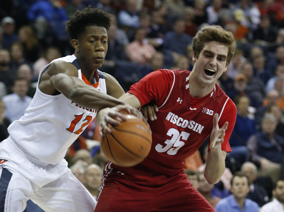 Wisconsin forward Nate Reuvers (35) and Virginia guard De’Andre Hunter (12) fight for a rebound. (AP)