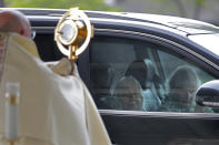 Parishioners pray from their car as Fr. Steve Buno, Pastor of St. Rita of Cascia Catholic Church in Harahan, La., performs drive-thru Benediction of the Blessed Sacrament, as a form of social distancing due to the new coronavirus, during Holy Week, Tuesday, April 7, 2020. (AP Photo/Gerald Herbert)