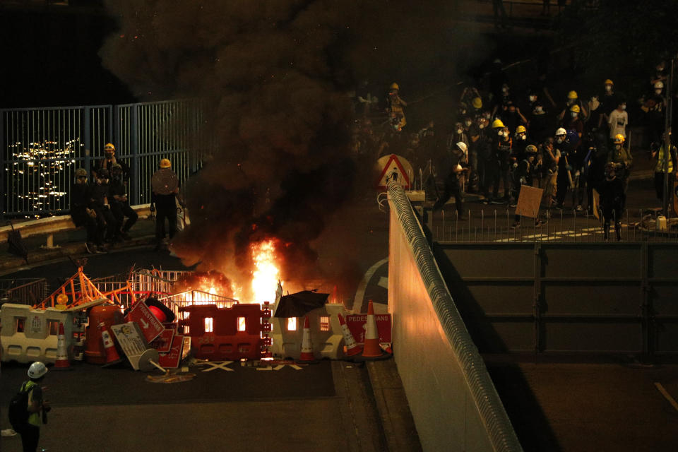 Protesters set fire to a barricade to prevent riot police officers from advancing in Hong Kong on Sunday, July 21, 2019. Hong Kong police launched tear gas at protesters Sunday after a massive pro-democracy march continued late into the evening. The action was the latest confrontation between police and demonstrators who have taken to the streets to protest an extradition bill and call for electoral reforms in the Chinese territory. (AP Photo/Bobby Yip)