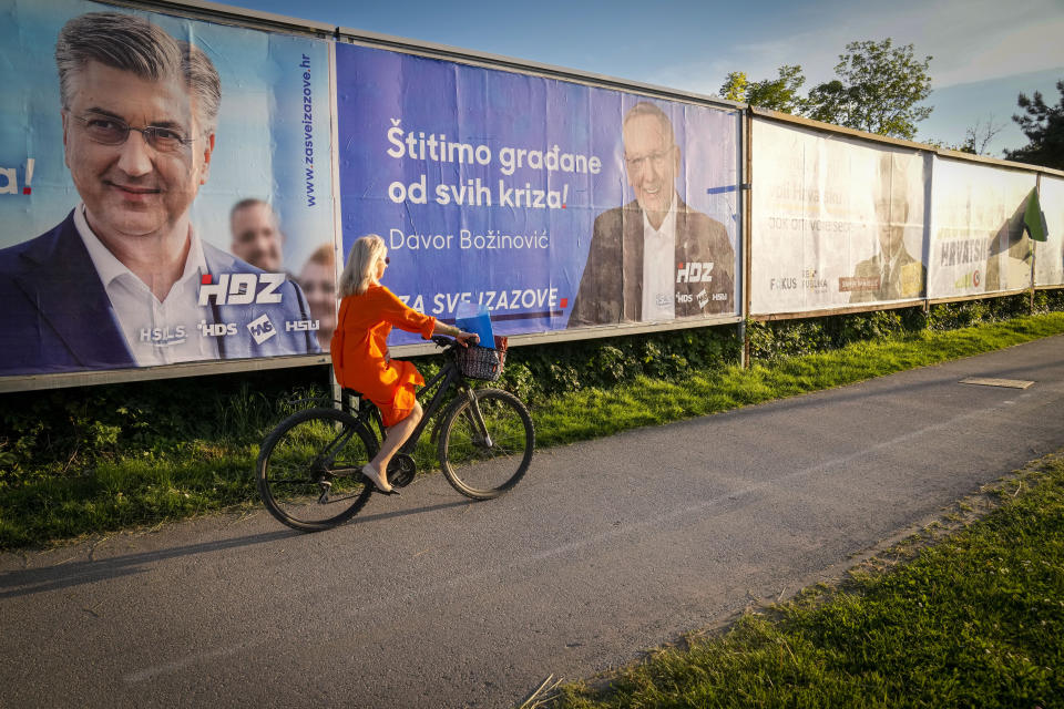 A cyclist rides past election posters in Zagreb, Croatia, Sunday, April 14, 2024. Croatia this week holds an early parliamentary election following a campaign that was marked by heated exchanges between the country's two top officials, creating a political crisis in the Balkan country, a European Union and NATO member state. (AP Photo/Darko Bandic)