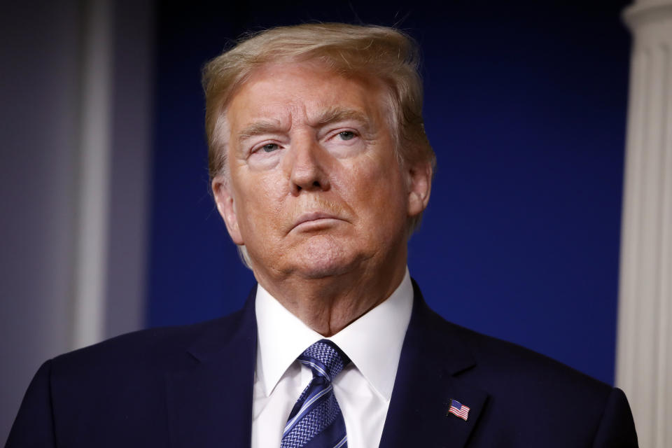 President Donald Trump listens as Treasury Secretary Steven Mnuchin speaks about the coronavirus in the James Brady Press Briefing Room of the White House, Tuesday, April 21, 2020, in Washington. (AP Photo/Alex Brandon)