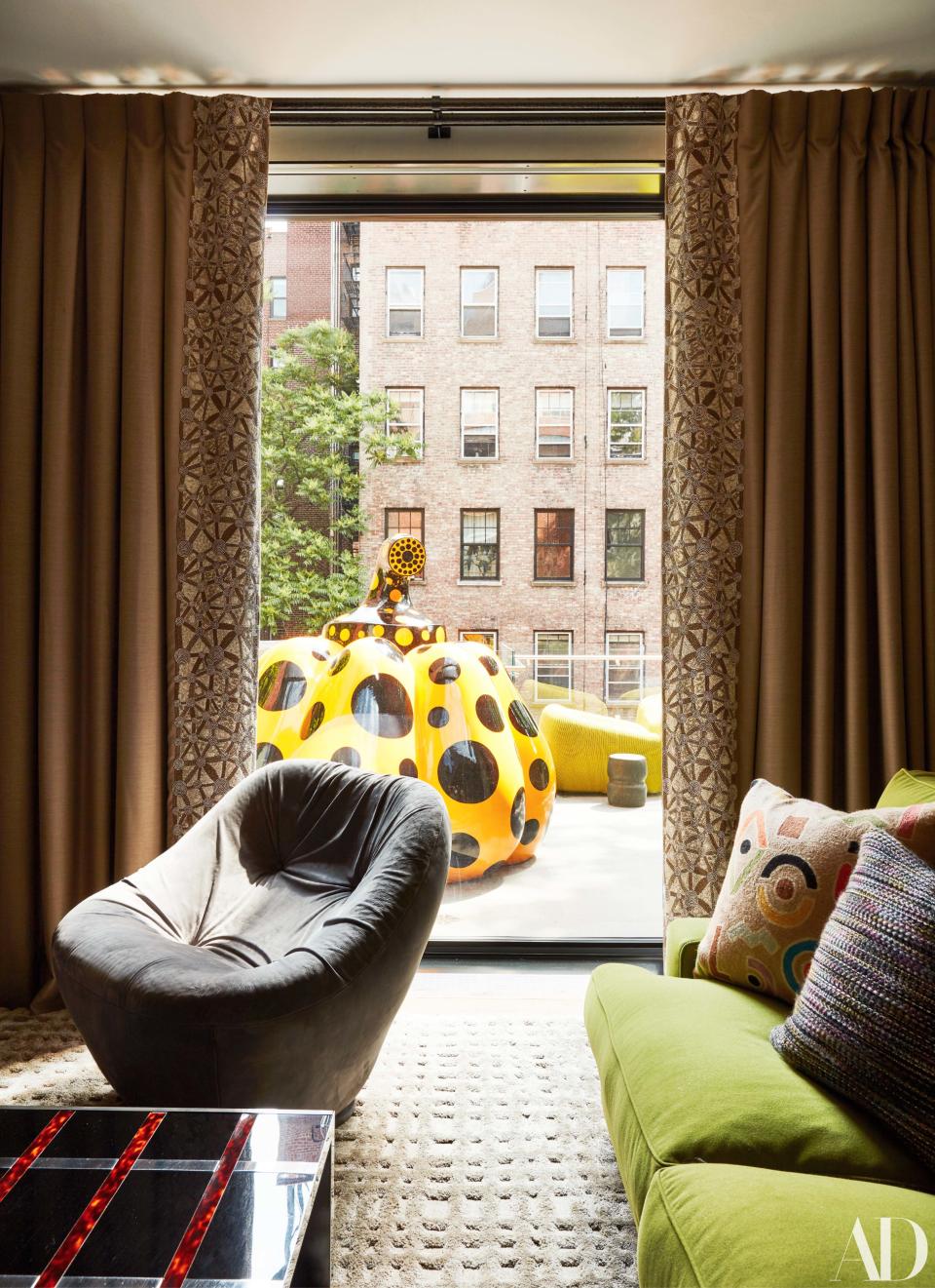 A pumpkin sculpture by Yayoi Kusama sits on a terrace outside the family room.