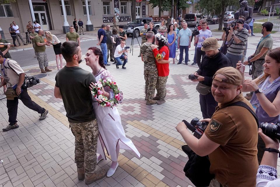 Soldiers Vitalii Orlich and his bride Kristina (L) and Volodymyr Mykhailuk and his bride Hrystyna dance after their joint wedding ceremony on June 12, 2022 in Druzhkivka, Donetsk Oblast, Ukraine. All four are soldiers in the Ukrainian army serving with the 14th separate mechanized brigade in eastern Ukraine. Both couples met while serving in the army after the start of the war with Russia. Ukrainian forces are engaged in a back-and-forth battle with Russia for key towns along the western edge of the Donetsk and Luhansk regions, where Moscow is focusing its firepower.