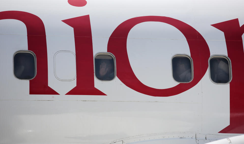 Yemeni prisoners peer through windows of a plane during their arrival after being released by the Saudi-led coalition at the airport in Sanaa, Yemen, Thursday, Oct. 15, 2020. (AP Photo/Hani Mohammed)